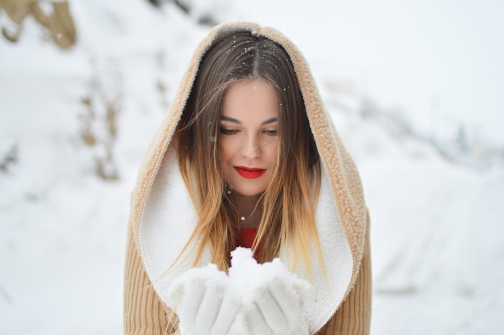 Mujer sosteniendo y mirando hielo durante el día