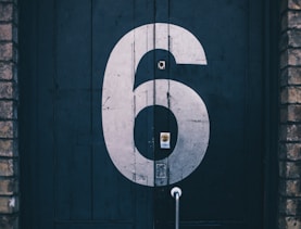 macro photography of blue wooden door painted with number 6