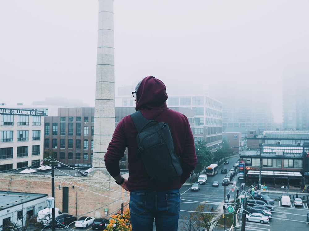 Mann, der tagsüber durch die nebelverhangene Stadt blickt