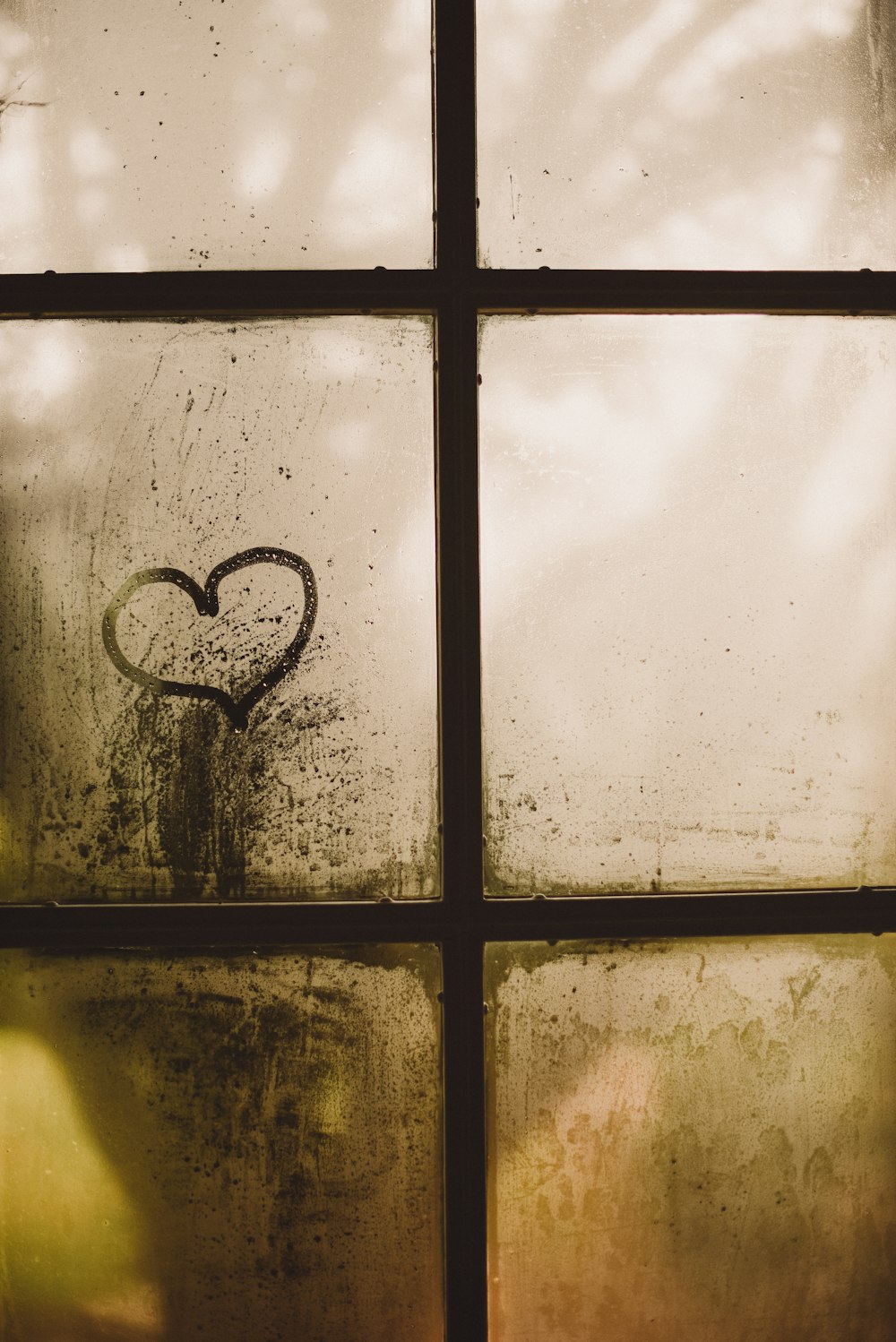 Ventana de vidrio con marco negro con dibujo de corazón