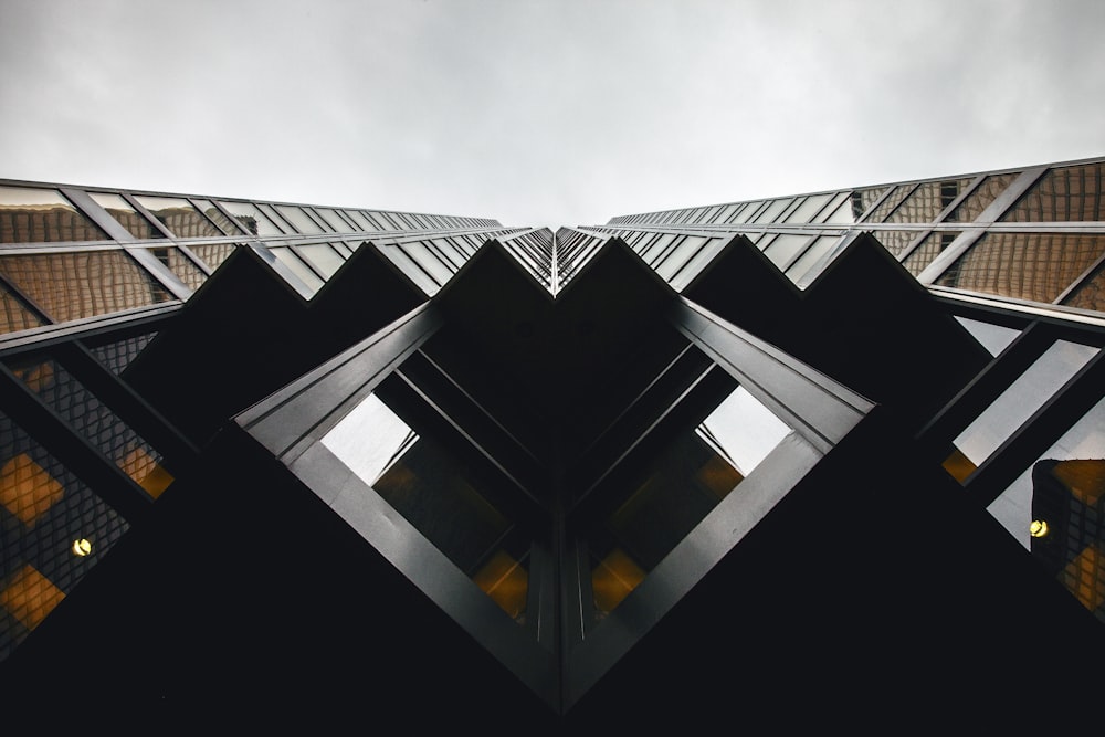 Fotografía de ángulo bajo de un edificio de gran altura marrón y negro bajo el cielo nublado