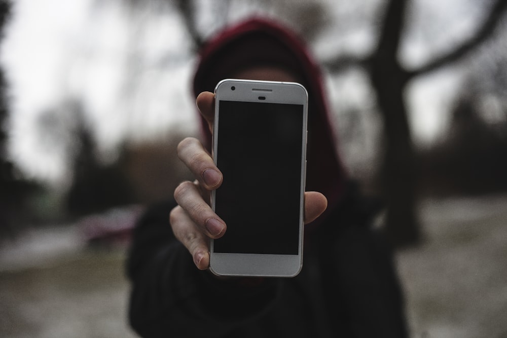 Fotografía con lente de cambio de inclinación de una persona que sostiene el teléfono inteligente cerca de la cámara