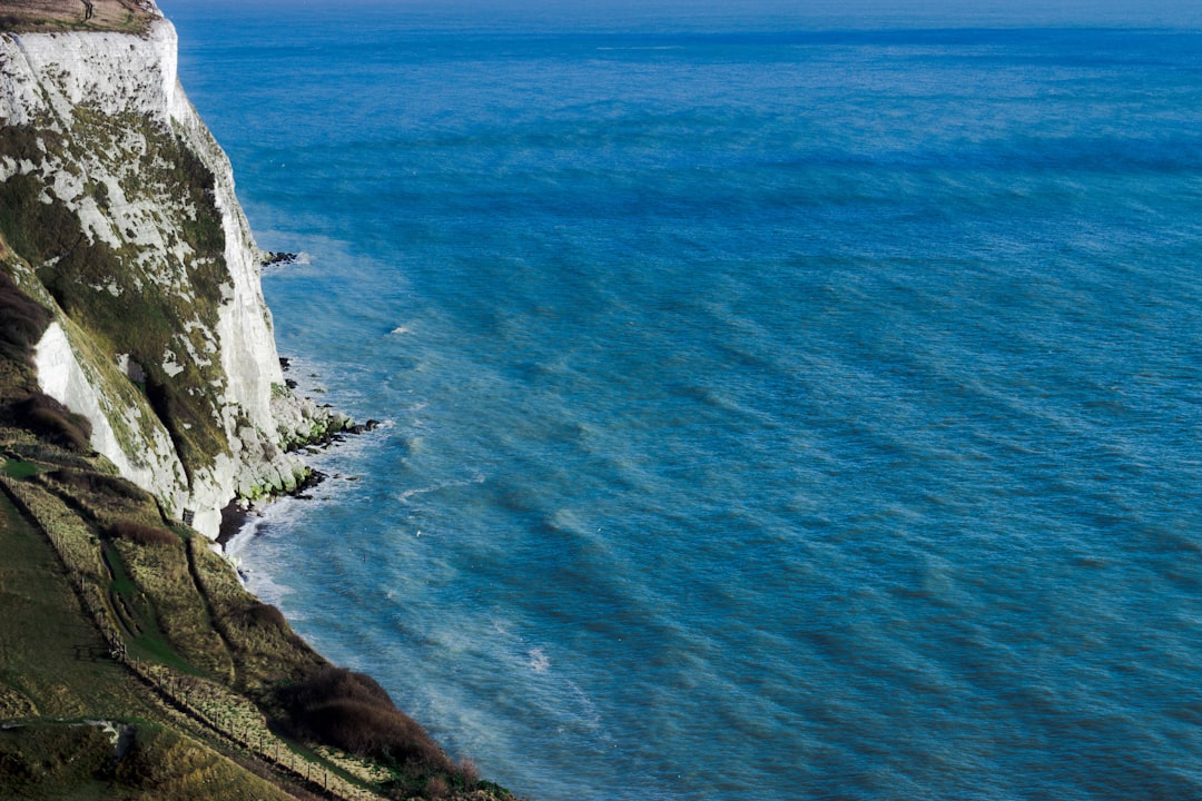 aerial photography of mountain cliff beside seashore during daytime