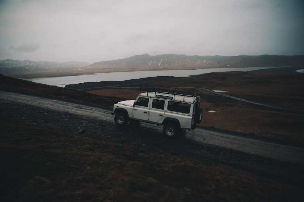 white sport utility vehicle running on road near field