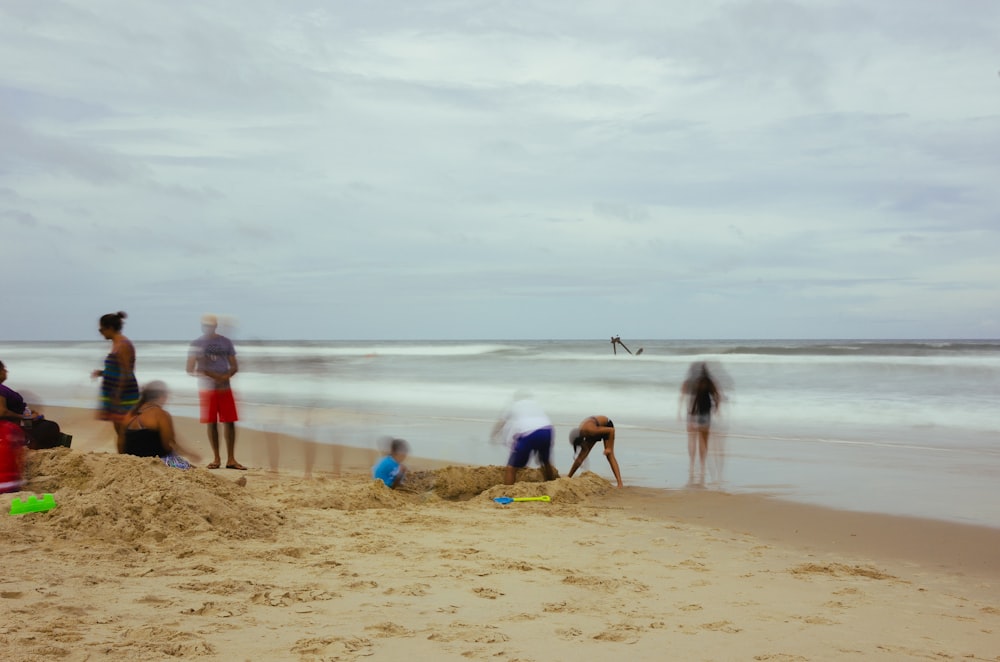 grupo de personas de pie en la orilla de la playa