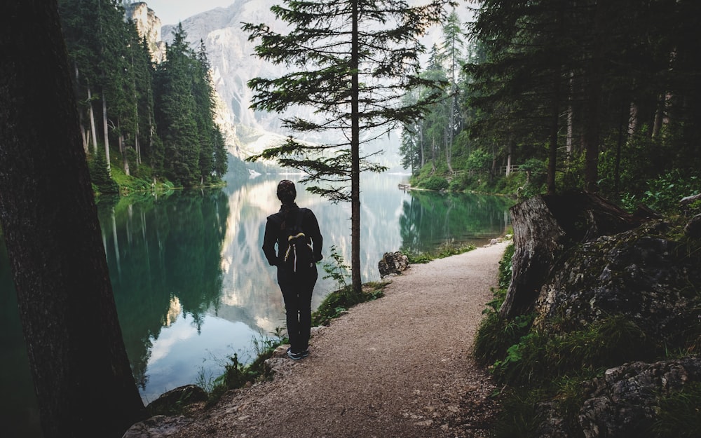 person stands near lake