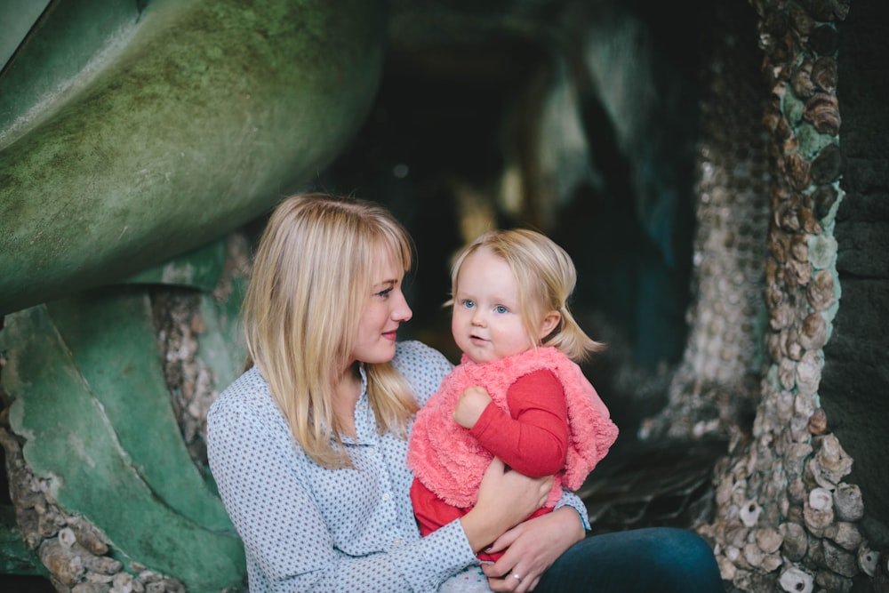 woman holding child while sitting down