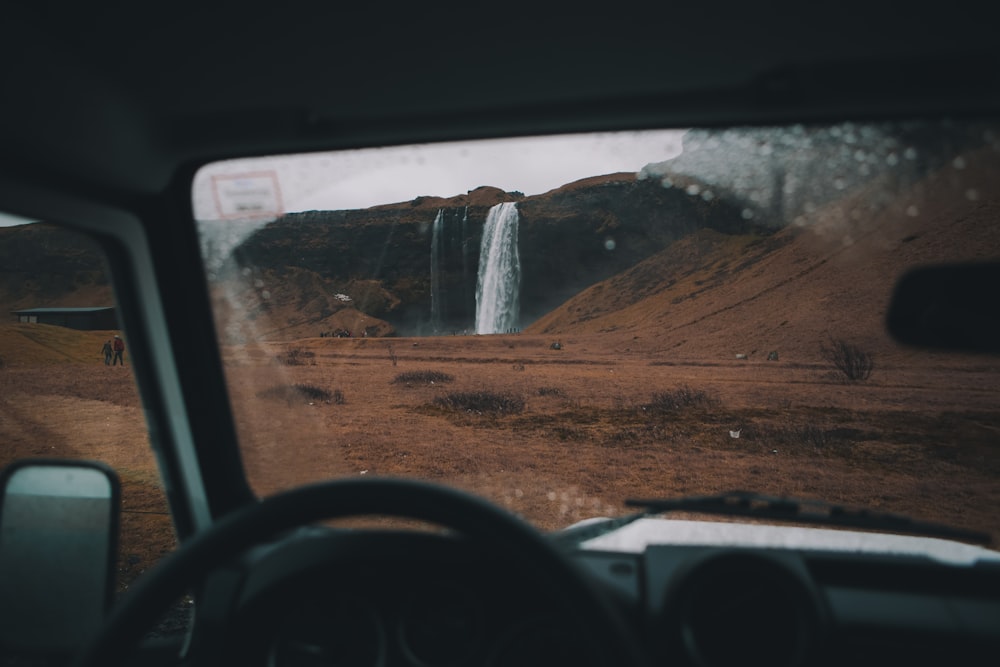 photo of people walking toward waterfalls