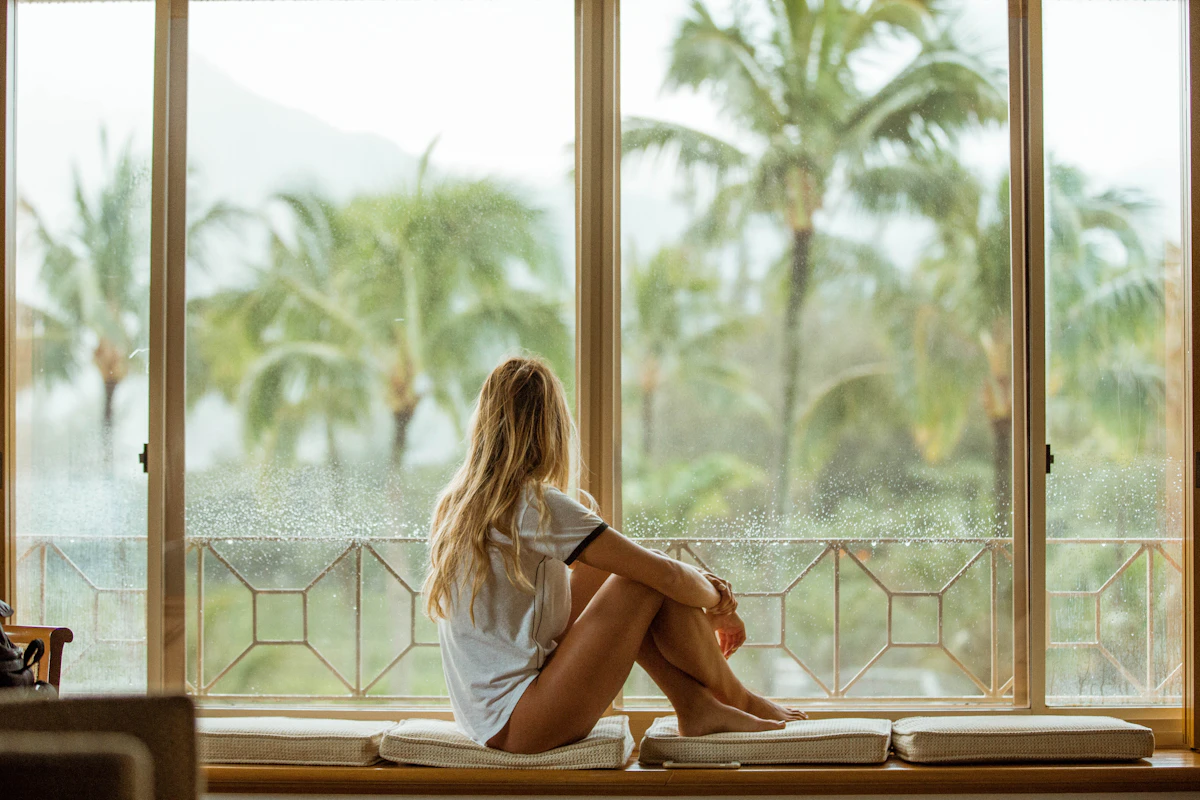 A woman sitting calmly by a bright window