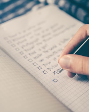 person writing bucket list on book