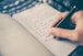 person writing bucket list on book