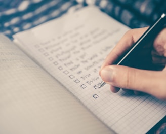 person writing bucket list on book