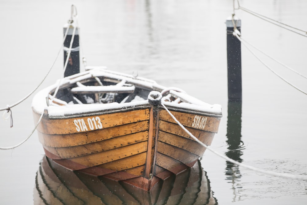 brown wooden boat on body of water