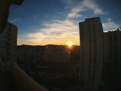 Sunset view over a large development plot with city lights in the distance.