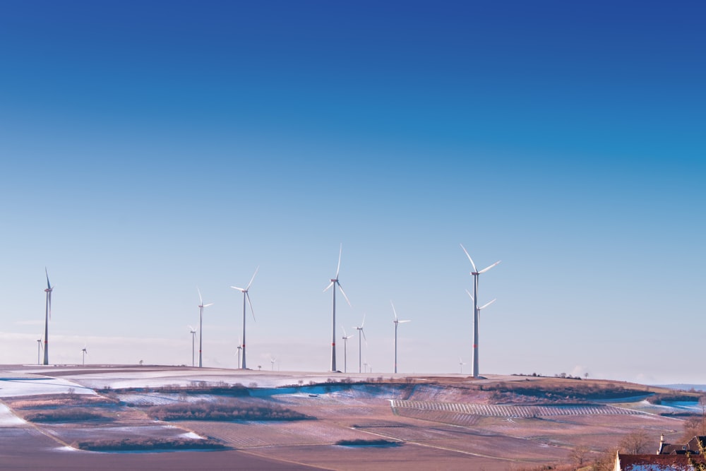 Éolienne blanche sur le désert gris sous le ciel bleu et blanc