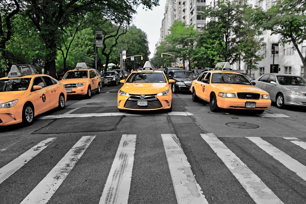 four yellow cars on gray road