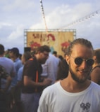 person wearing white crew-neck shirt beside crowd