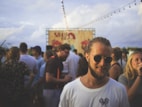 person wearing white crew-neck shirt beside crowd