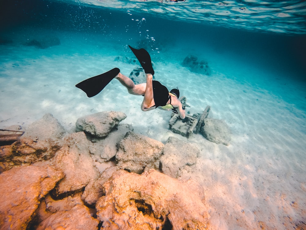 person wearing diving suit underwater shallow focus photography