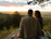 A happy couple enjoying a sunset picnic next to their HF trailer in a scenic mountain area.