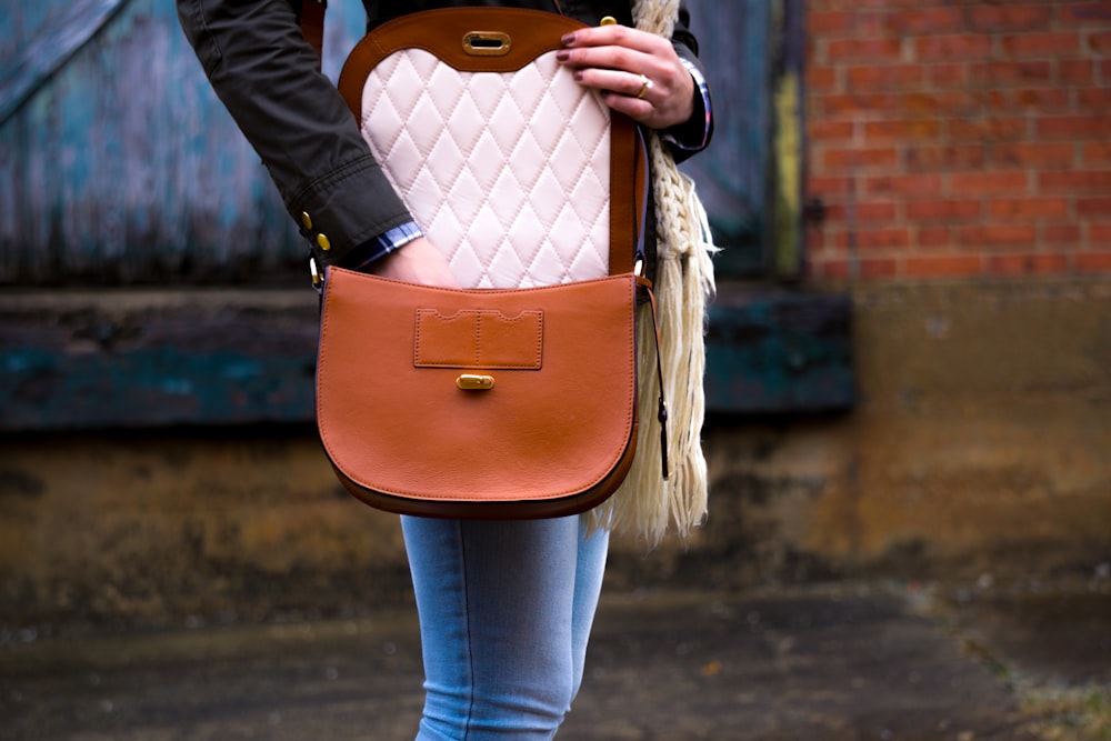 femme portant un sac à bandoulière en cuir rouge