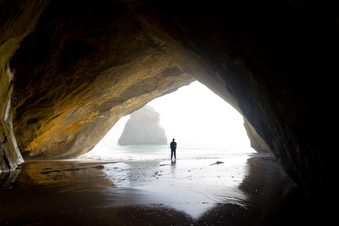photography of person standing in cove