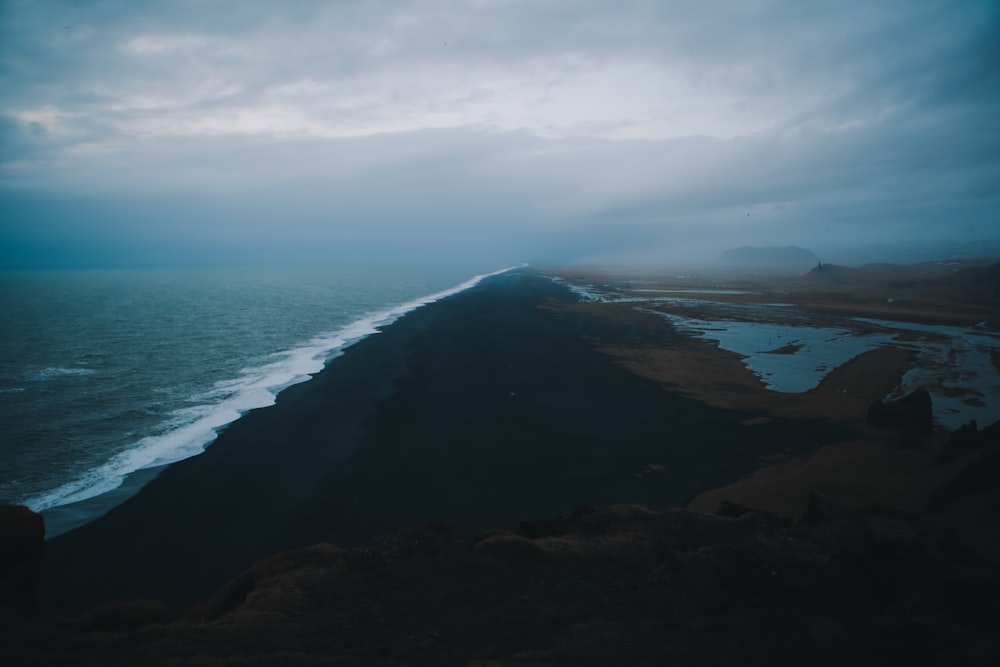 aerial photo of mountains and body of water