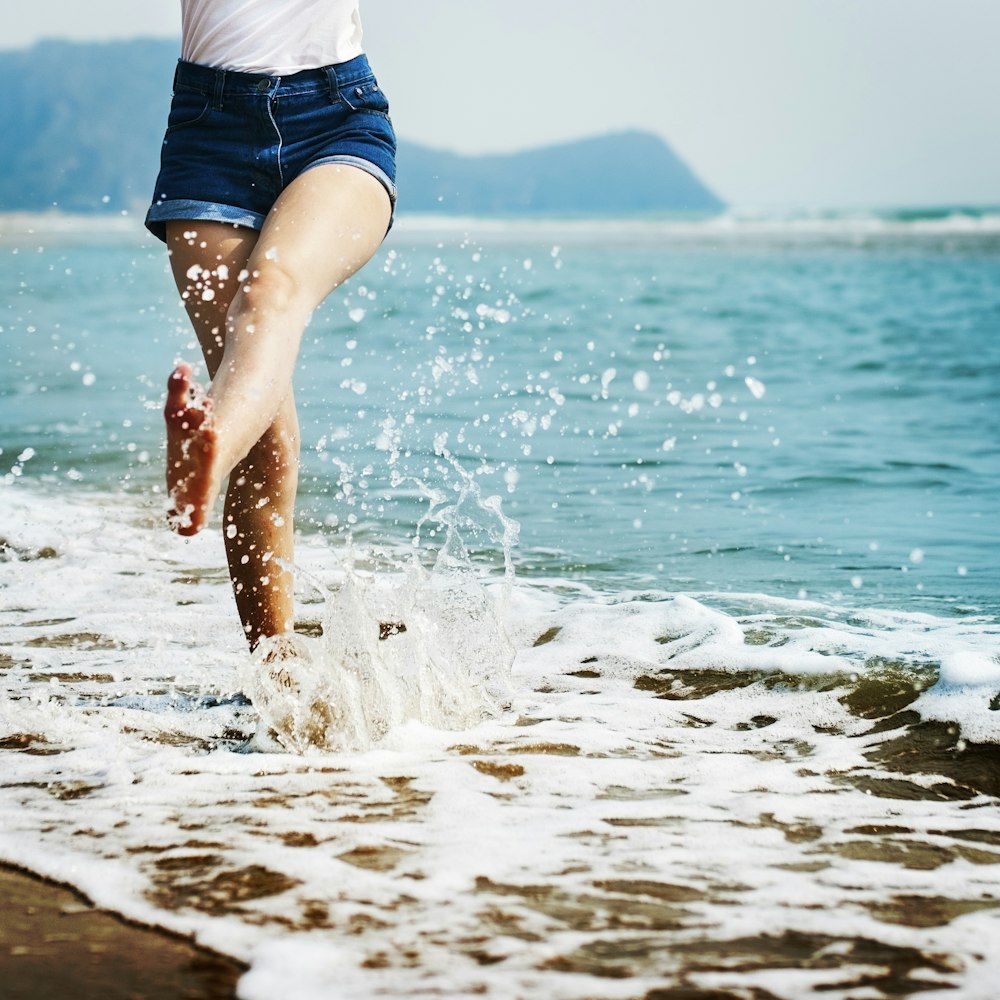 woman wearing blue denim shorts on seashore