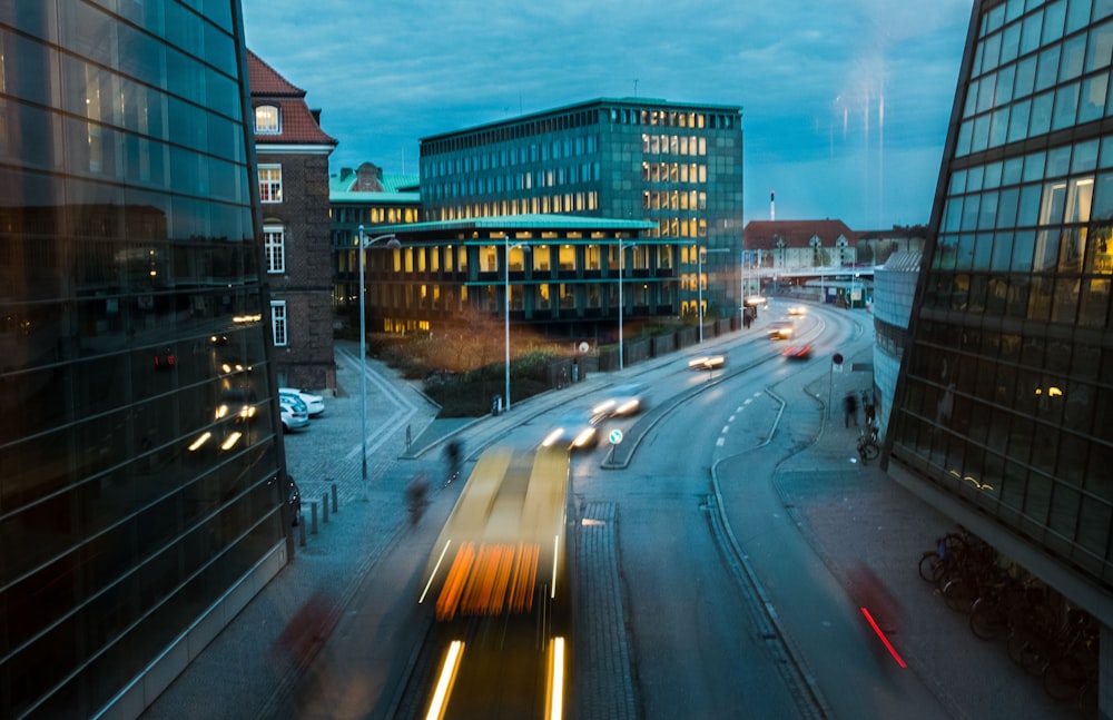 timelapse photography of vehicle near curtain buildings