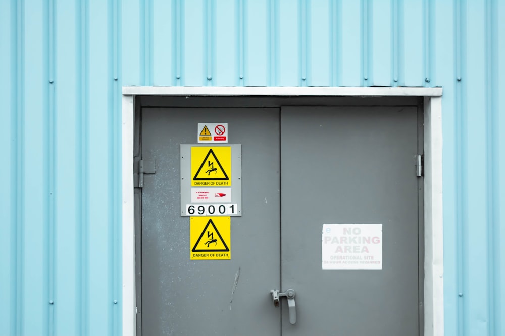 gray steel door with warning sign