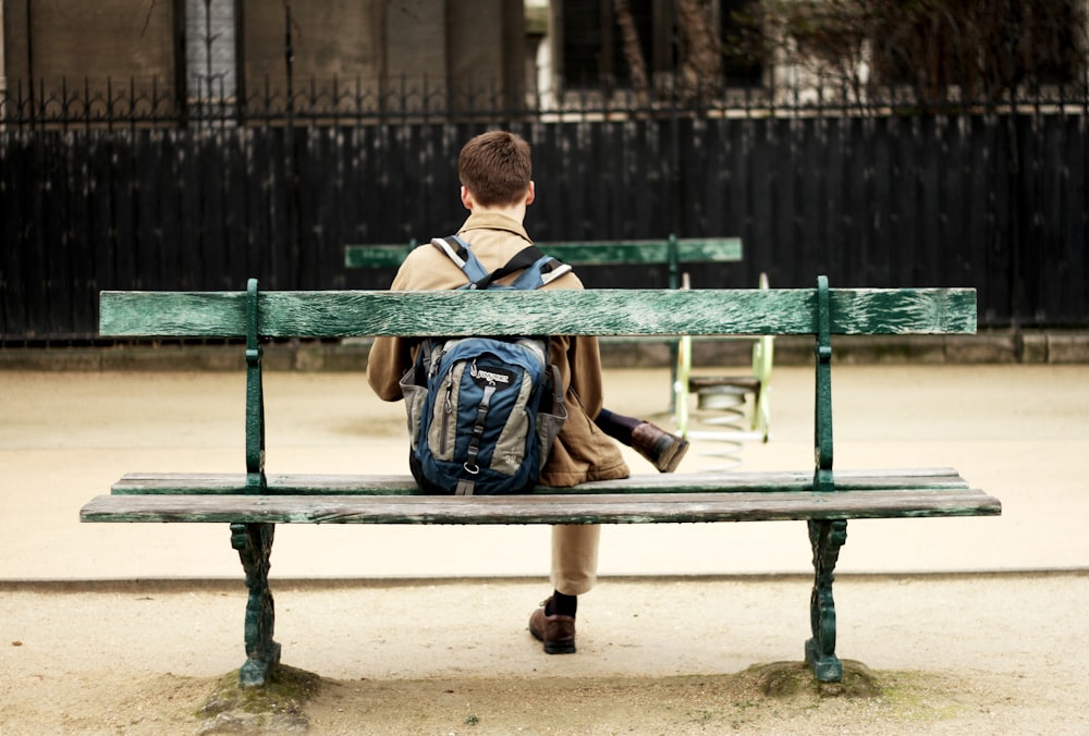 man in brown shirt sitting on bench