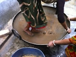 Hands gently mixing cow dung and other natural ingredients for the diyas.