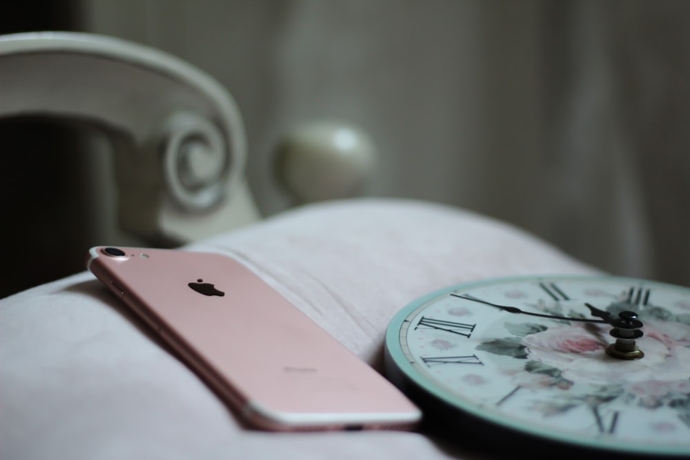 rose gold iPhone 8 near round analog clock