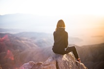 woman sitting on a rock mountain