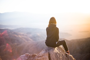 woman sitting on a rock mountain