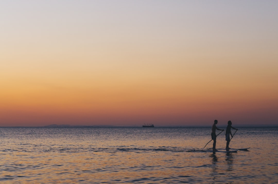 two person kayaked on ocean during golden hour