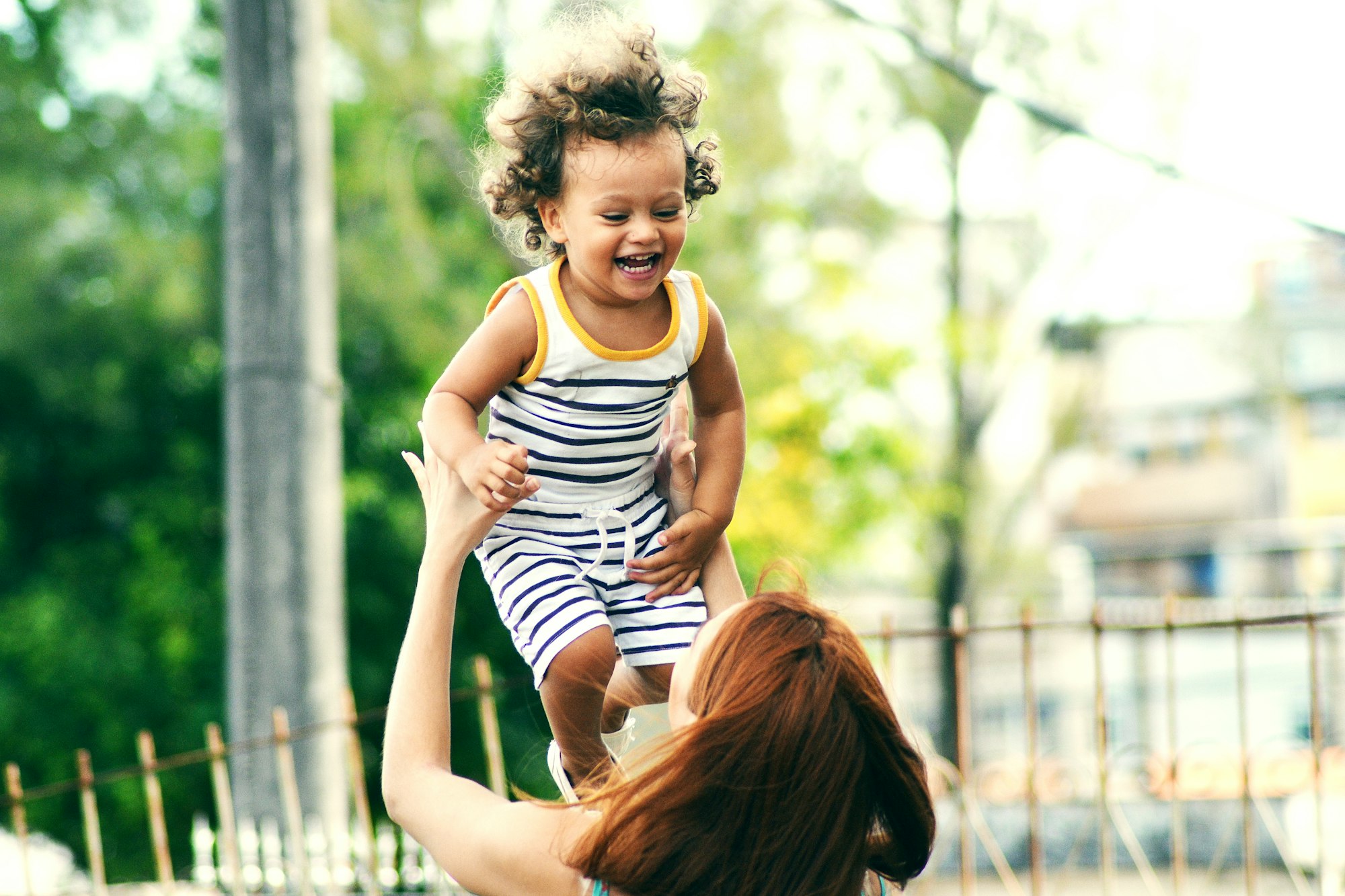 A mother lifting her daughter in the air