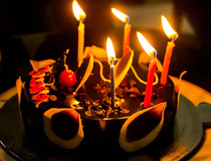 A beautifully decorated chocolate cake centerpiece surrounded by candles and heartfelt notes.
