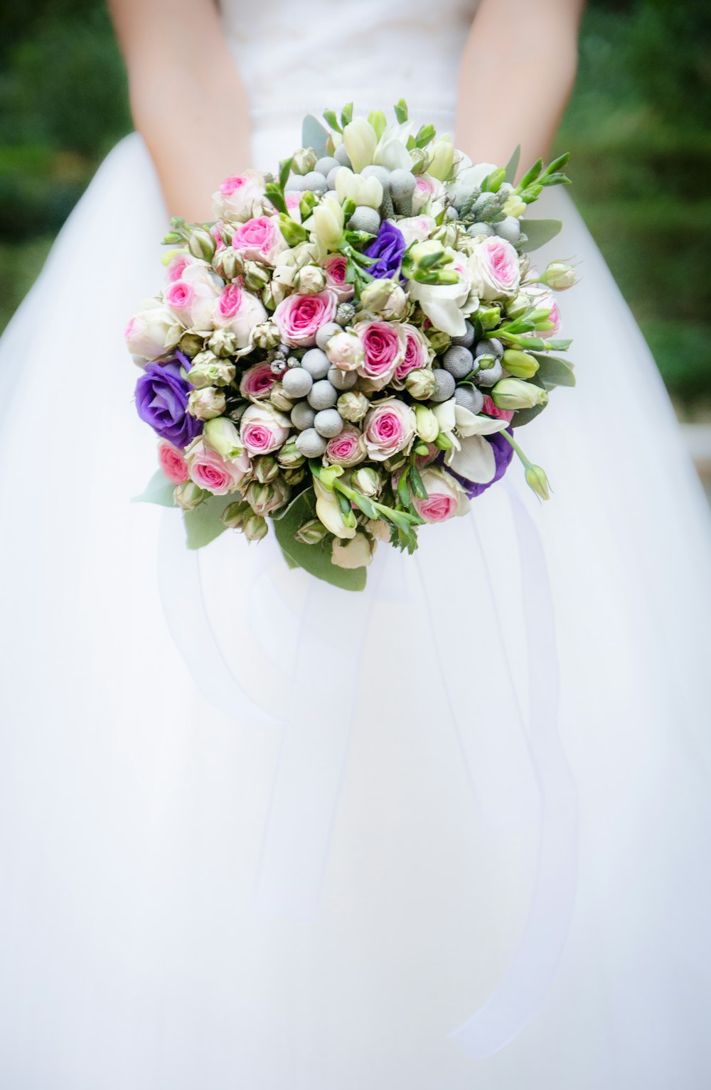 femme tenant un bouquet de fleurs blanches et roses