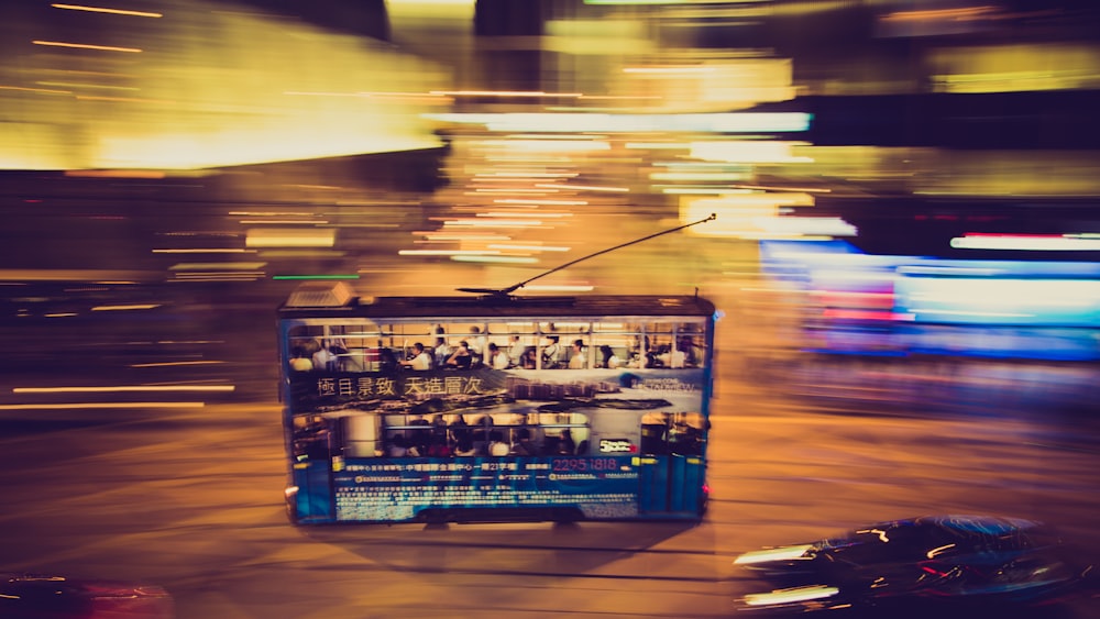 Double decker bus in motion moves through the night on Hong Kong Island