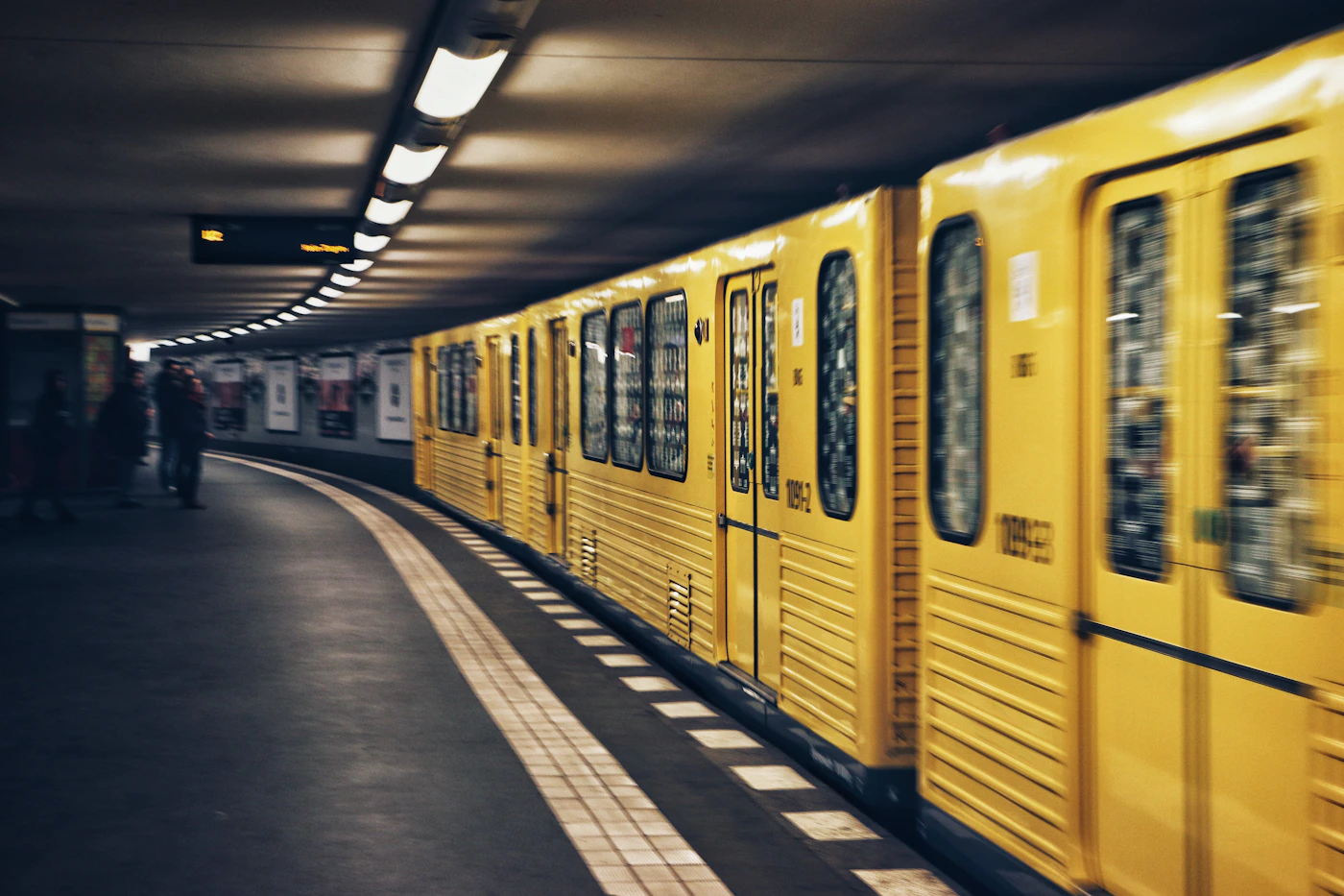 Yellow train entering a dark tunnel