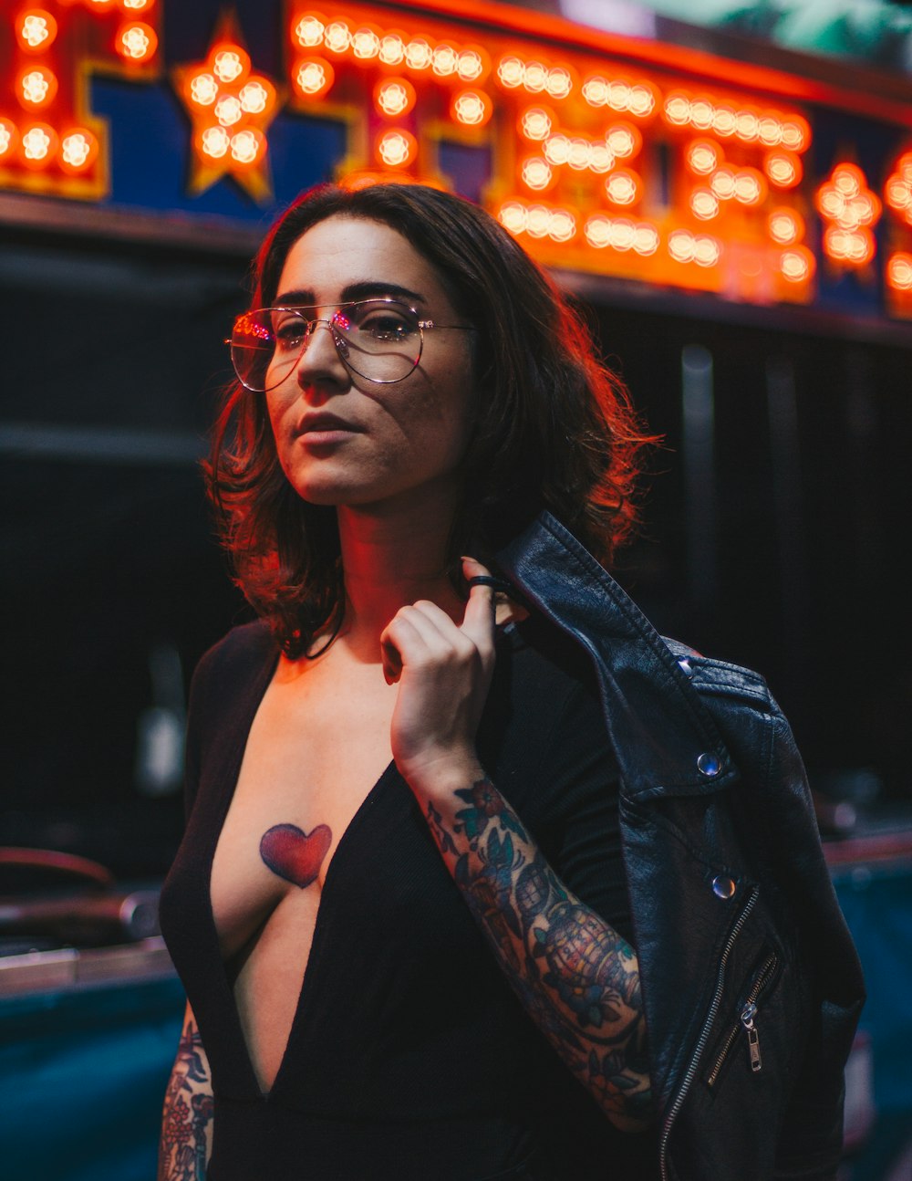 woman in black plunging-neckline holding black leather jacket photo