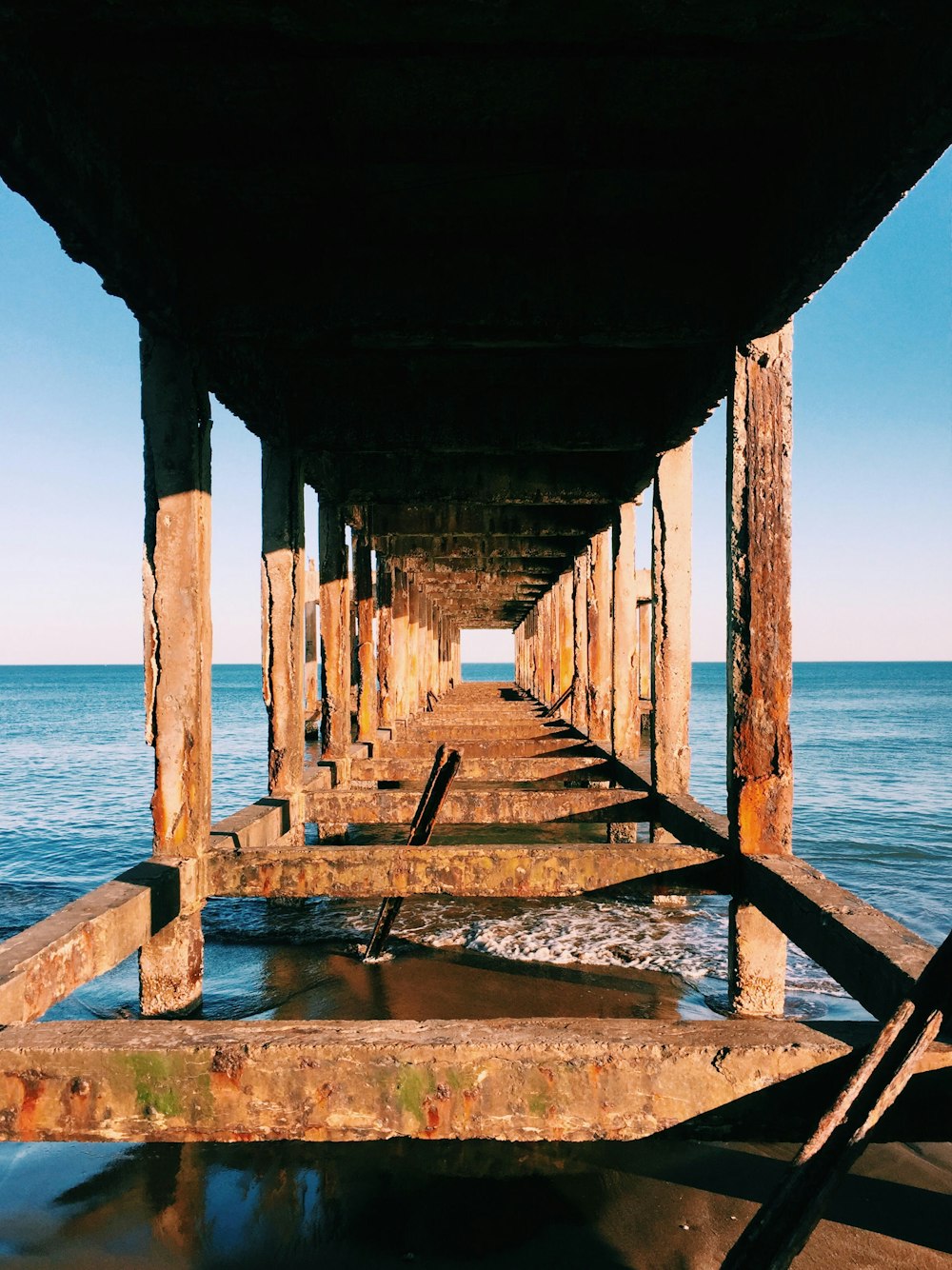 a long wooden pier sitting on top of a beach
