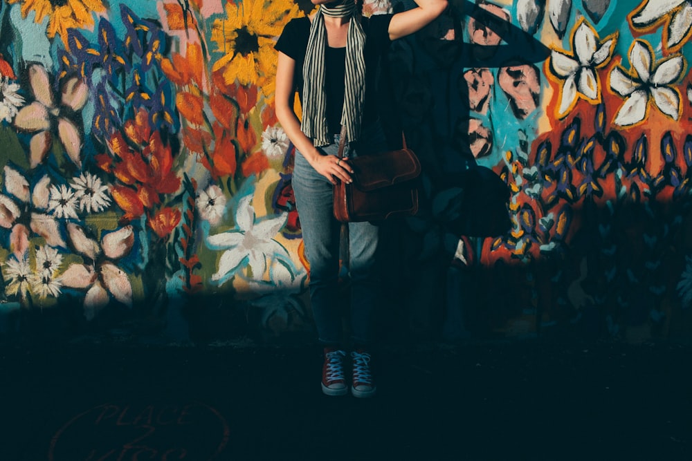 woman stand in front of floral graffiti