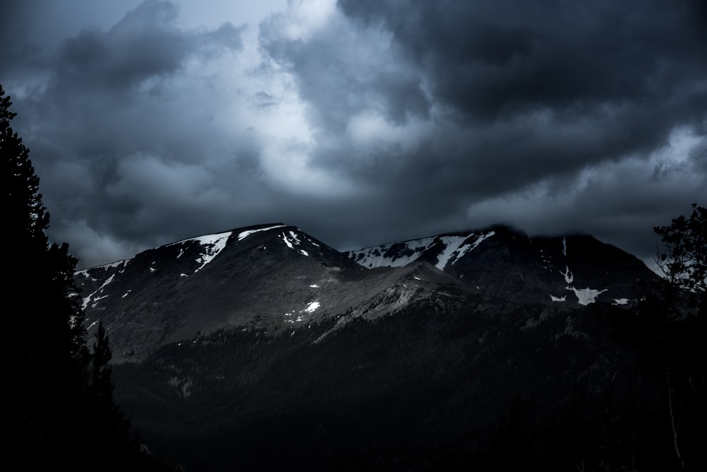 灰色の雲の下に雪に覆われた山脈