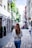 woman wearing gray top walking on sidewalk during daytime