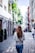 woman wearing gray top walking on sidewalk during daytime