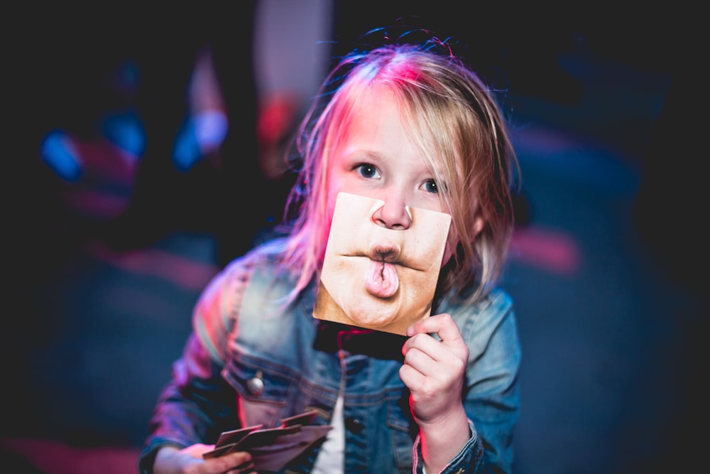 child holding photo of lips