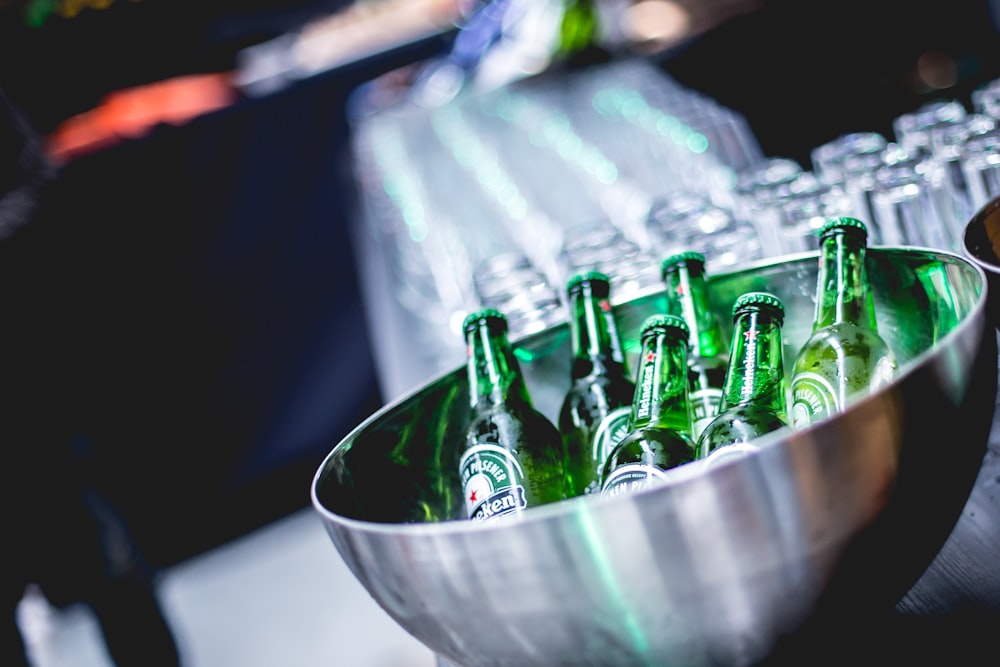 green glass bottles in stainless steel bowl