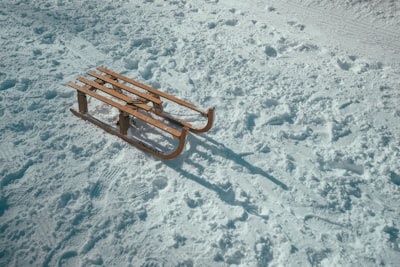 brown sled on snow during daytime sleigh zoom background